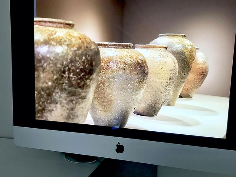 电脑屏幕上的手工花瓶的图像从展览火木燃烧.